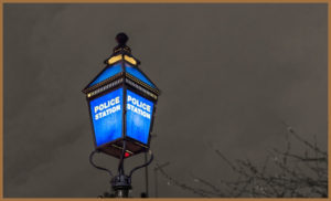 A lit police lantern outside a police HQ