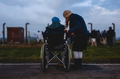 A woman looking after an autistic person in a wheelchair