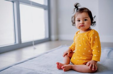 An autistic baby sat in the centre of a room