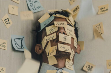 An autistic man covered in sticky notes with phrases on about slowing down