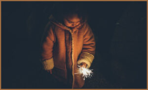 A young autistic girl playing with a sparkler