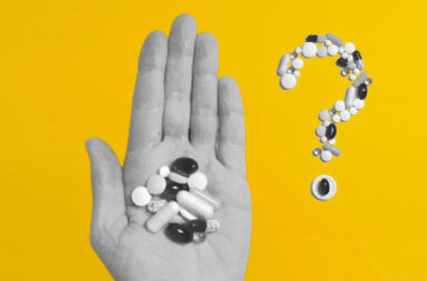 A hand holding autism medication next to a question mark make out of pills