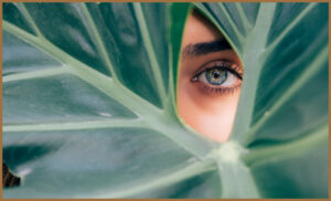 A woman hiding behind a leaf