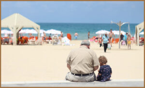 A grandparent with autistic grandchild on beach