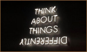 Neon sign that says 'Think About Things Differently'