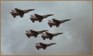 Military jets flying through the air in formation