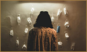 An autistic woman looking at a wall of empty masks
